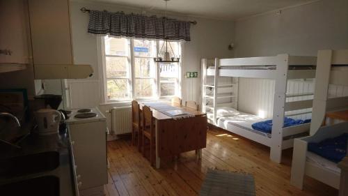 a room with two bunk beds and a desk at Vandrarhemmet Lotsen in Dalarö