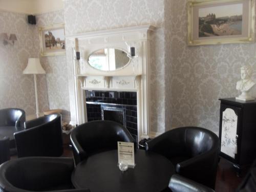 a room with a table and chairs and a fireplace at Powys Lodge in Scarborough