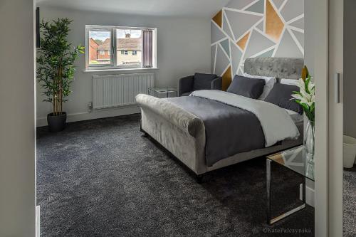 a bedroom with a bed and a couch and a window at Like Your Own Private Hotel in Luton