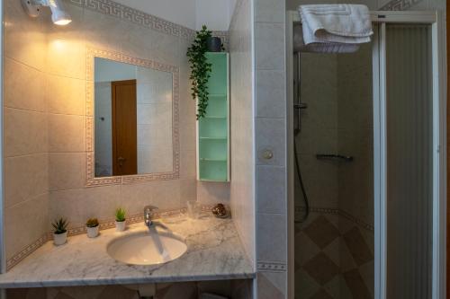 a bathroom with a sink and a mirror and a shower at Accogliente Trilocale Turone a due passi dal mare in Martinsicuro