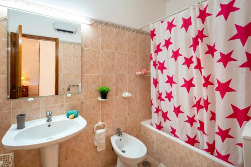 La salle de bains est pourvue d'un lavabo et d'un rideau de douche avec des étoiles. dans l'établissement Apartamentos Casa Brito, Boliqueime by AlgarveBlossom, à Boliqueime