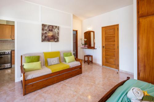 a living room with a couch with yellow and green pillows at Apartamentos Casa Brito, Boliqueime by AlgarveBlossom in Boliqueime