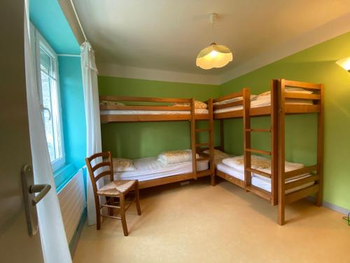 Cette chambre comprend 3 lits superposés et une chaise. dans l'établissement La Margeride, à Serverette