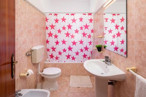 a bathroom with a toilet and a sink with red stars on the wall at Apartamentos Casa Brito, Boliqueime by AlgarveBlossom in Boliqueime