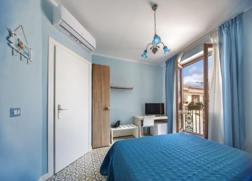 a bedroom with a blue bed and a window at La stanza dell'angolo in Maratea