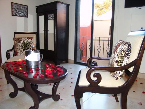 a room with a table and a chair with roses on it at Casa del Tio Hotel Boutique in San Miguel de Allende