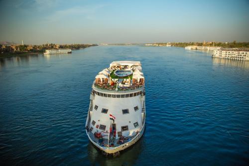 a large boat in the middle of a river at Champollion II 5 Stars Nile cruise in Luxor