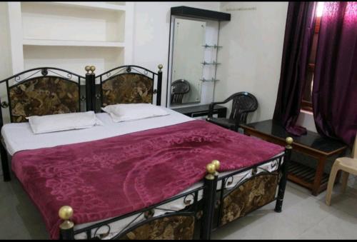 a bedroom with a large bed with a purple blanket at Couple Friendly Hotel - Sunset in Orchha