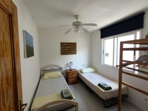 デニアにあるApartamento Riomarの二段ベッド2台と窓が備わる客室です。