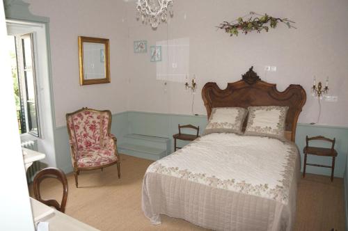 1 dormitorio con 1 cama y 1 silla en Chambres d'hôtes Le Grand Air - Les châteaux de la Brie aux portes de Paris, en Ozouer-le-Voulgis