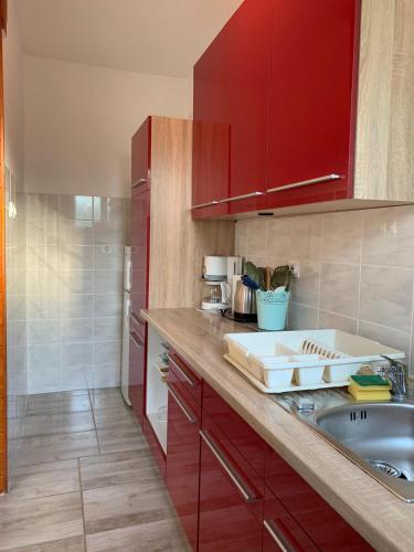 a kitchen with red cabinets and a sink at Danijela in Mali Lošinj