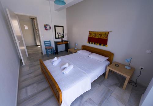 a bedroom with a large bed with towels on it at Katapola Vekris apartments in Katapola