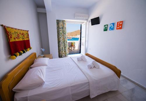 una camera da letto con un letto bianco e asciugamani di Katapola Vekris apartments a Katápola