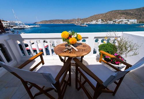 un tavolo e sedie su un balcone con vista sull'oceano di Katapola Vekris apartments a Katápola