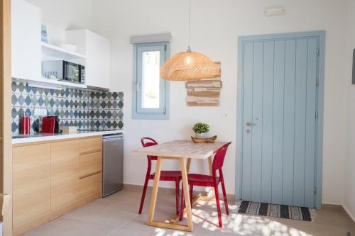 a kitchen with a table and a blue door at Two Goats Villas in Kyra Panagia