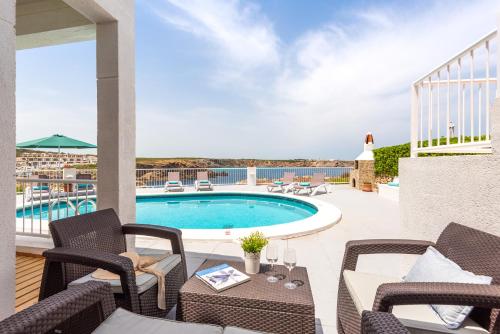 a patio with chairs and a swimming pool at Villa Margarita in Es Mercadal
