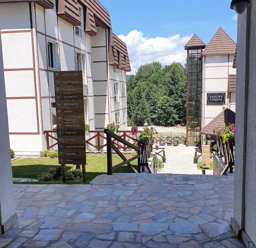 an entrance to a building with a sign and flowers at Planinska bajka - Kraljevi čardaci in Kopaonik