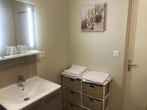 a bathroom with a sink and a mirror at La Villa Port Winston - Face Mer B&B in Saint-Côme-de-Fresné