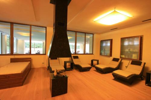 a large room with a bed and couches and windows at Residence Anda in Pozza di Fassa