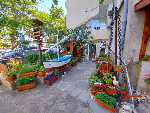 a garden center with plants and a boat on the side of a building at SEA ROOM Nesebar in Nesebar