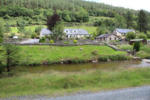 a house on a hill next to a river at Riversdale House room only accommodation, A98KD85 in Brockagh