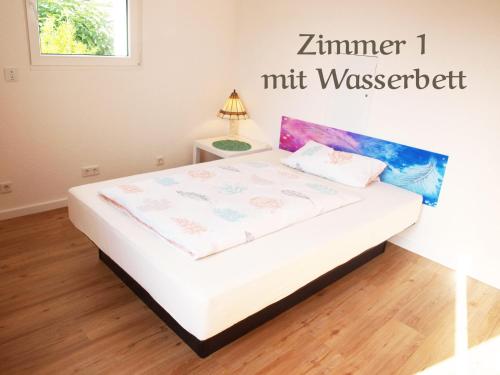 a bed in a room with a sign that reads zermier nutzik at 123 Zimmerfrei in Schoneck