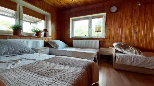 a bedroom with two beds and two windows at Agroturystyka KRAINA JEZIOR in Ludwin