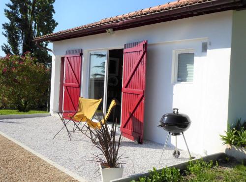 a house with red doors and a grill at Gîte Etchola in Ramous