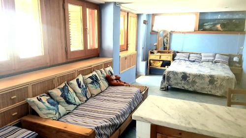 a bedroom with a couch and a bed and windows at Villa Calamona in Acciaroli