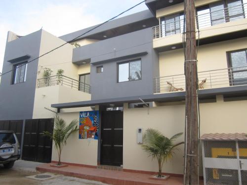a house with palm trees in front of it at La Villa 126 Dakar in Dakar