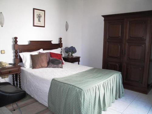 1 dormitorio con 1 cama grande y armario de madera en A Moderna - CALDAS DA FELGUEIRA en Caldas da Felgueira