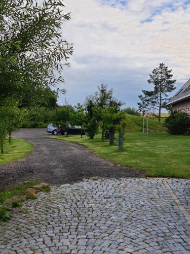 a cobblestone road with a car parked in a field at Na Kopečku AD 1795 - penzion s restaurací a wellness v Podkrkonoší in Dvůr Králové nad Labem