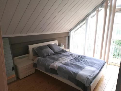 een slaapkamer met een bed en een groot raam bij maison 3 chambres à 200 m de la plage des Barrages de l Eau d Heure in Froid-Chapelle