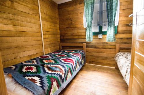 a bedroom with a bed in a room with wooden walls at Vajat Tuk in Bajina Bašta