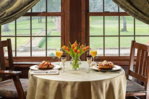 una mesa con dos platos de comida y flores en ella en Hilltop Manor B&B, en Hot Springs