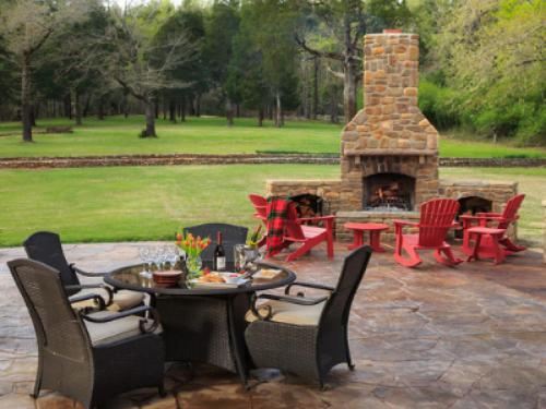 a patio with a fireplace and tables and chairs at Hilltop Manor B&B in Hot Springs