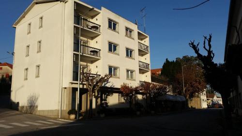 a white building with balconies on the side of it at A Moderna - Guest house Casa dos Serpas in Caldas da Felgueira