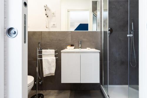 een badkamer met een witte wastafel en een douche bij Hotel Aurora in Lignano Sabbiadoro