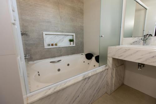 a bathroom with a sink and a mirror at BM Hotel in São Sebastião do Paraíso