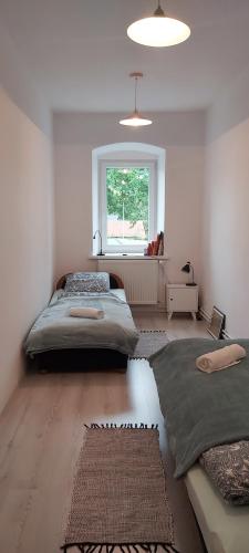 a bedroom with two beds and a window at Kamienica Radków in Radków