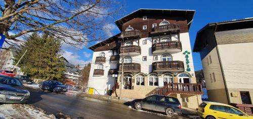 a tall building with balconies on a city street at Pensiunea Alpin Predeal in Predeal