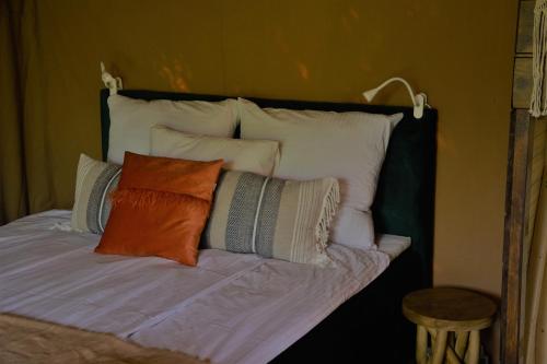 a bed with several pillows on top of it at Beskidylla glamp in Ustroń