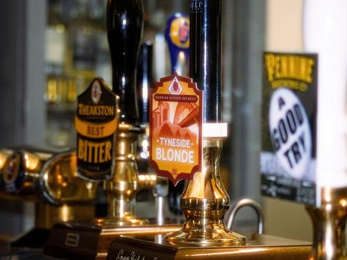 a bar with two bottles of beer on a counter at Horseshoe Hotel in Whitby