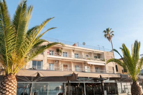 un hotel con palmeras delante en Di fronte alla fortezza, en Nauplia