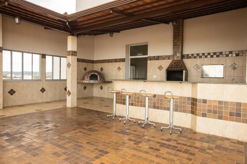 a room with stools in the middle of a kitchen at BM Hotel in São Sebastião do Paraíso