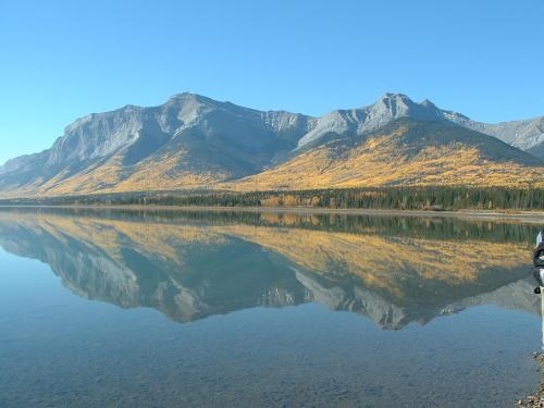 a reflection of a mountain in the water with trees at Black Cat Guest Ranch in Brule Mines