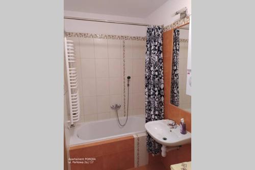 ein Badezimmer mit einer Badewanne und einem Waschbecken in der Unterkunft Apartament Poręba, dwupoziomowy, 8-osobowy in Szklarska Poręba