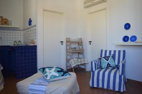um quarto com duas cadeiras azuis e brancas e uma mesa em Casa Blue em Favignana