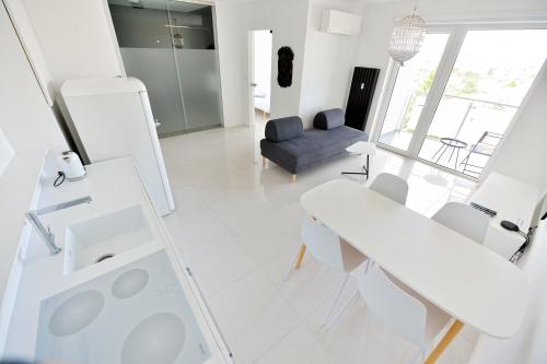ein weißes Wohnzimmer mit einem Tisch und einem Stuhl in der Unterkunft City Center Aupark Apartment in Piešťany