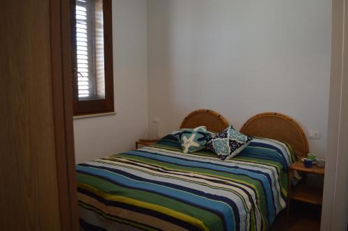 un letto con due cuscini sopra in una stanza di Casa Blue a Favignana